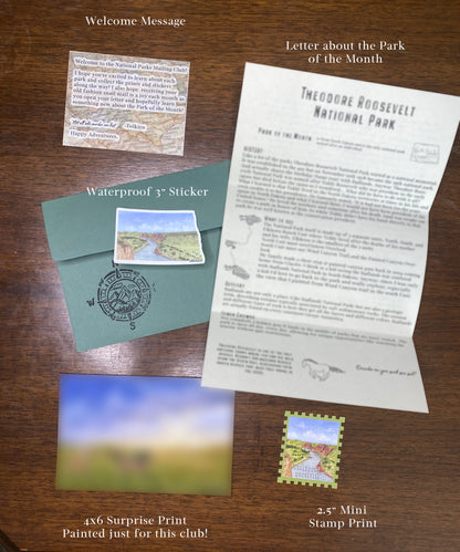Collection of Theodore Roosevelt National Park merchandise including a letter, postcard, and stickers on a wooden surface.